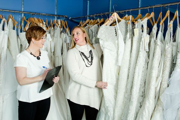 Owners Heidi Nicholson and Lisa Almeida (holding Allure® gown) selecting this season’s most popular gowns to display in the storefront. They make multiple international and national buying trips each year to bring their customers the very best the fashion world has to offer. Photo ©Shawn Black Photography
