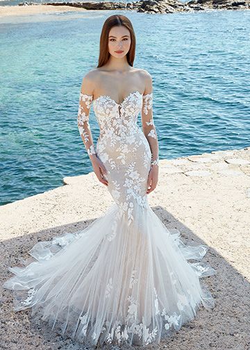Alexa is a figure-loving mermaid whimsically appliquéd with floral laces and lined with delicate Chantilly lace, atop a nude stretch mesh lining. Its soft tulle skirt scattered with appliqués on the hem moves beautifully, and matching detachable sheer lace sleeves pairs with its sweetheart neckline