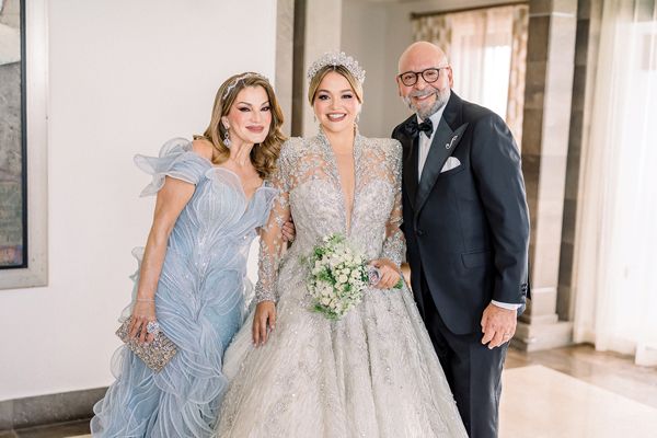 Andrea Damaris Santiago Díaz with her parents, store owners Damaris Díaz and Andrés Santiago, on her wedding day.