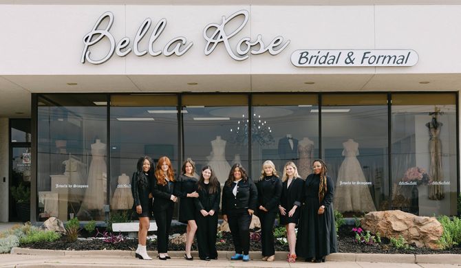 The Bella Rose Bridal and Formal team poses in front of the store’s flagship location. Owner Petra Simpson is pictured fifth from left.