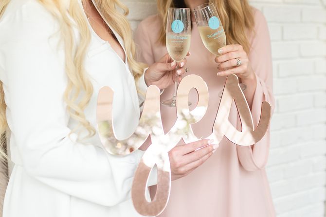 Each “yes” is celebrated with a champagne toast and photo-worthy sign.