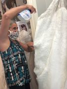 Country Bridals owner Cathy Furze sprays a bridal gown with a fabric sanitizer, a practice she instituted after her 18-year-old boutique reopened on May 11 after nearly two months of being closed due to the novel coronavirus pandemic. (Courtesy of Country Bridals & Formal Wear)
