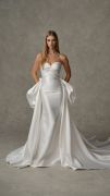 Deanna: Strapless radzimir gown featuring a sweetheart neckline, softly draped bodice, and fitted skirt. Finished with a detachable overskirt accented by floral detail at the back waist.