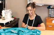 Head Seamstress Dayna Nosal, apprentice to Maria, works on a dress.