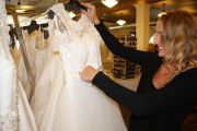 A bridal consultant selecting a gown for her customer to try on.