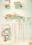 Subtle touches, such as gold hands holding up glass shelves, add elegance.