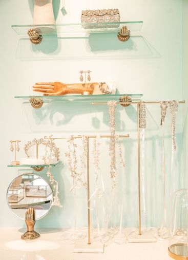 Subtle touches, such as gold hands holding up glass shelves, add elegance.