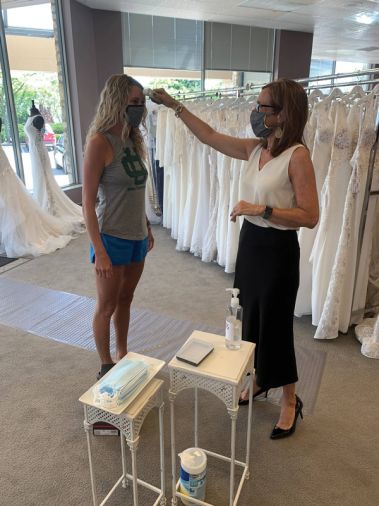 Wendy’s Bridal general manager Lilly Stalnaker takes the temperature of a bride at the entrance of the Dublin, Ohio-based boutique. Temperature scans were one of the many policies Wendy’s instituted amid COVID-19. (Courtesy of Wendy’s Bridal)
